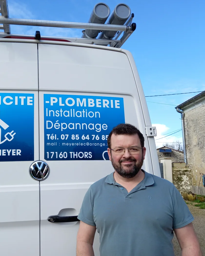 Portrait de l'électricien plombier devant son camion d'intervention